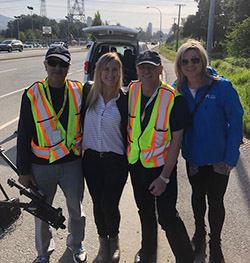4 volunteers standing on roadside