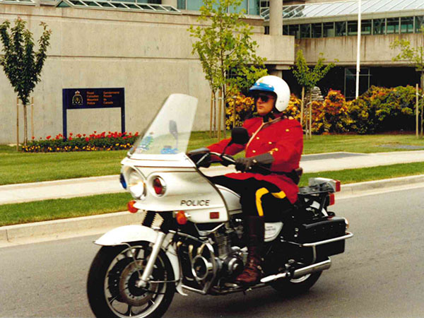Photo of Dale Carr in Red Serge on a motorcycle